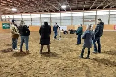 A group of people standing in an indoor arena.