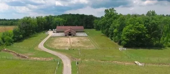 A large barn with a lot of trees in the background