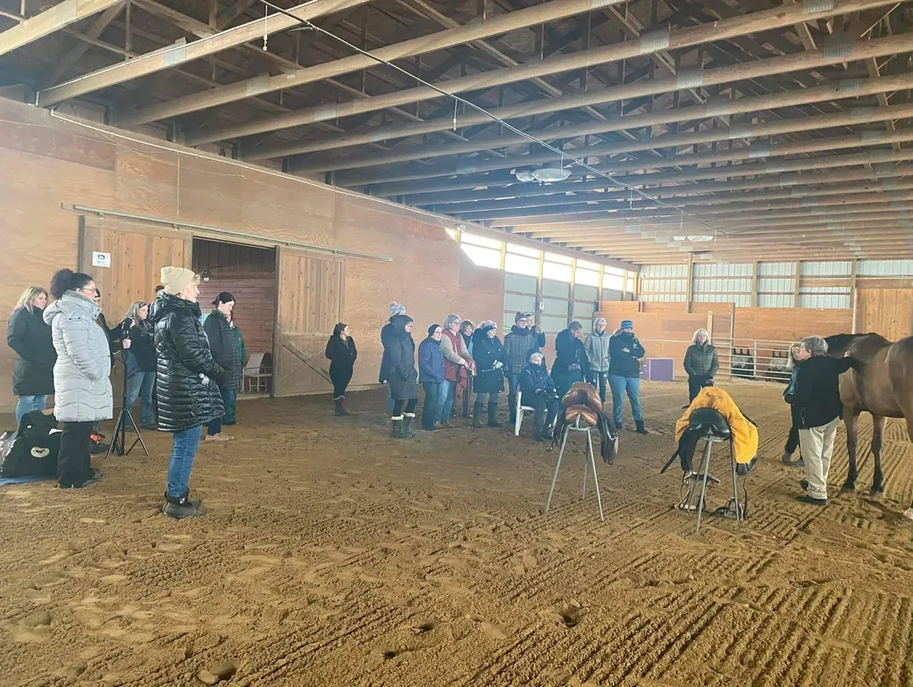 A group of people standing in an indoor arena.