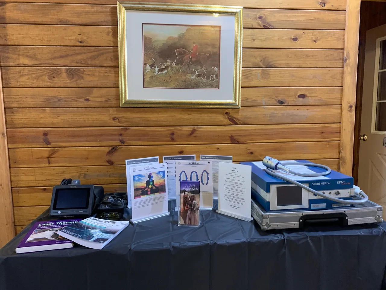 A table with several items on it and a picture hanging above.